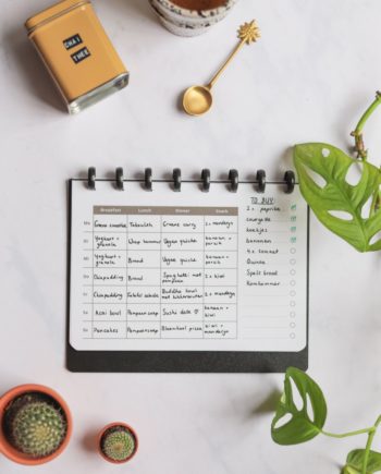 Erasable nutrition planner next to assorted items on marble background