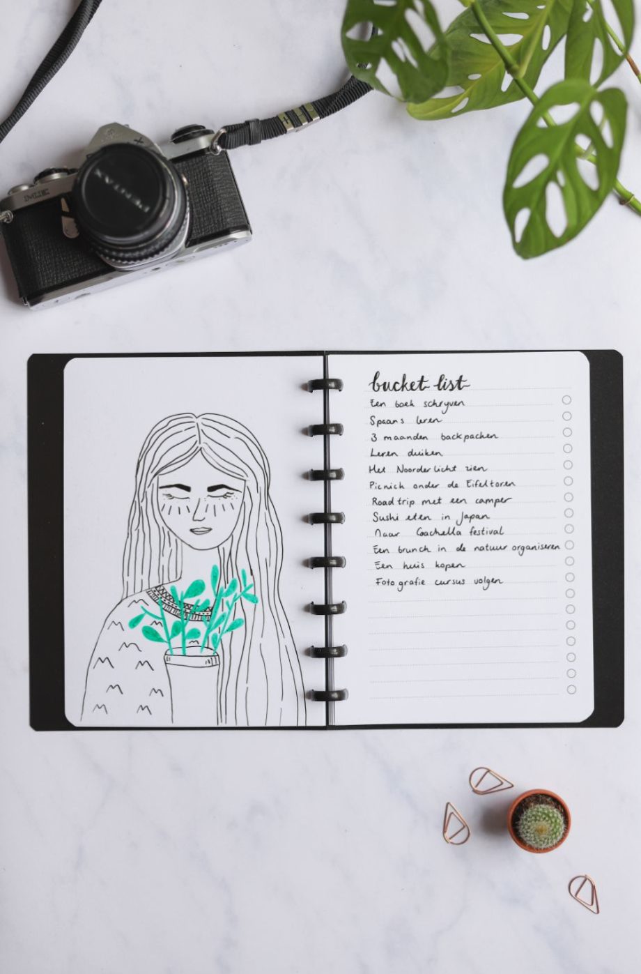 Erasable blank page with drawing of girl and erasable to-do list next to assorted items on marble background